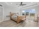 Bright main bedroom boasts a wood bed frame, lots of natural light from several windows, and trey ceilings at 127 Garden Gate Way, Summerville, SC 29486