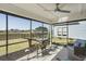 Relaxing screened porch with seating and a view of the manicured lawn and fountain at 127 Garden Gate Way, Summerville, SC 29486