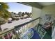 A cozy balcony with outdoor furniture overlooks palm trees and a parking lot at 1300 Ocean Blvd # 221, Isle of Palms, SC 29451