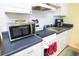 A compact kitchenette featuring modern appliances, sleek countertops, and ample cabinet space at 1300 Ocean Blvd # 221, Isle of Palms, SC 29451
