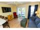Bright living room featuring a ceiling fan, tv, couch, and access to the outdoors at 1300 Ocean Blvd # 221, Isle of Palms, SC 29451