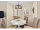 Bright dining area with a round table, four wicker chairs and two windows with sunny natural light at 1407 Shipwatch Rd, Kiawah Island, SC 29455