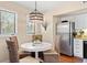 Bright dining area with a round table, four wicker chairs, and stainless steel fridge near bright, sunny windows at 1407 Shipwatch Rd, Kiawah Island, SC 29455