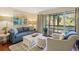 Comfortable living room with natural light, sliding doors to outdoor seating, and modern coastal decor at 1407 Shipwatch Rd, Kiawah Island, SC 29455