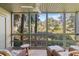 Relaxing screened porch with ceiling fan and comfortable seating, offering serene views of the lush surroundings at 1407 Shipwatch Rd, Kiawah Island, SC 29455