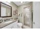 Bathroom with tiled walk-in shower, vanity, granite counters, framed mirror and ample lighting at 15 Back Ct, Isle of Palms, SC 29451