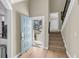 Bright foyer with an open blue door, hardwood floors, and a carpeted staircase at 15 Back Ct, Isle of Palms, SC 29451