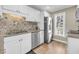 Bright kitchen features stainless steel appliances, white cabinets, and granite countertops at 15 Back Ct, Isle of Palms, SC 29451