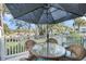 Enjoy outdoor dining on this patio with umbrella-covered table set overlooking the serene pond at 15 Back Ct, Isle of Palms, SC 29451
