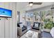 Enjoy this screened-in porch with chairs, decor, ceiling fan, and views of the exterior landscaping at 15 Back Ct, Isle of Palms, SC 29451