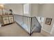 Carpeted staircase with black metal railing, leading to the downstairs area; display cabinet at 15 Back Ct, Isle of Palms, SC 29451