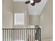 View of the upstairs railing and staircase with a window and a ceiling fan above at 15 Back Ct, Isle of Palms, SC 29451