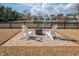 Cozy backyard with brick patio, fire pit, and lake views offering a tranquil outdoor setting at 158 Sandshell Dr, Charleston, SC 29492