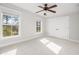 Bright bedroom with neutral carpet, two windows, and a ceiling fan and closet at 158 Sandshell Dr, Charleston, SC 29492
