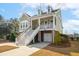 Charming two-story home featuring garages, inviting porch, and classic American architectural details at 158 Sandshell Dr, Charleston, SC 29492