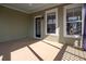 Covered porch with light green walls, and brown painted wood flooring and a back door at 158 Sandshell Dr, Charleston, SC 29492