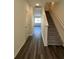 Inviting entryway featuring sleek wood floors, staircase with white railing, and abundant natural light at 1703 Scarlett Maple St, Summerville, SC 29486