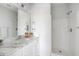This bathroom features a white marble countertop, vanity, mirror, and shower with a white tub surround at 2021 Arbutus Ave, North Charleston, SC 29405