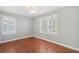 A well-lit bedroom featuring hardwood floors, neutral walls, and plantation shutters at 204 William St, Mount Pleasant, SC 29464