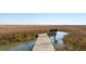 Marsh front home with a private wooden dock and bench, providing tranquil waterfront access at 204 William St, Mount Pleasant, SC 29464