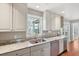 Kitchen features white cabinets, stone counters, a stainless dishwasher and hardwood floors at 204 William St, Mount Pleasant, SC 29464