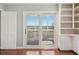 Living room features hardwood floors, sliding glass door to the outside porch, and white built in cabinets at 204 William St, Mount Pleasant, SC 29464