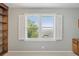 Window with white shutters, showcasing a serene landscape view, enhances natural light at 204 William St, Mount Pleasant, SC 29464
