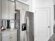 Close-up of a stainless steel refrigerator complementing gray cabinetry and granite countertops in the kitchen at 211 Tall Grass Ct, Summerville, SC 29483
