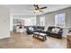 Open-concept living room with hardwood floors, ceiling fan, and ample natural light, flowing into the modern kitchen at 211 Tall Grass Ct, Summerville, SC 29483