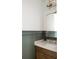 Stylish bathroom vanity with sage green paneling, stone countertops, and modern fixtures, creating a soothing and elegant space at 2151 Arthur Rose Ln, Johns Island, SC 29455