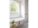 Bright bathroom with freestanding soaking tub, shiplap accent wall, and large window offering natural light and a view of the outdoors at 2151 Arthur Rose Ln, Johns Island, SC 29455