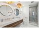 Modern bathroom with dual sinks, decorative mirrors and lighting fixtures, plus a gorgeous tiled shower at 220 W Arctic Ave, Folly Beach, SC 29439