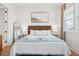 Inviting bedroom with a wicker headboard, accent wall paneling, and natural light from the large window at 220 W Arctic Ave, Folly Beach, SC 29439