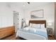 Comfortable bedroom featuring wood floors, wainscoting, a wicker headboard, and a dresser at 220 W Arctic Ave, Folly Beach, SC 29439
