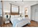 Bright bedroom features wood floors, white walls, closet, and adjoining bathroom with modern fixtures at 220 W Arctic Ave, Folly Beach, SC 29439