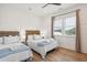 This bedroom features two beds, light hardwood floors, white walls and a window with natural lighting at 220 W Arctic Ave, Folly Beach, SC 29439