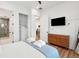 Bright bedroom features wood floors, white walls, closet, and TV above a wooden dresser at 220 W Arctic Ave, Folly Beach, SC 29439