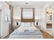 Well-lit bedroom featuring wood floors, an accent wall, and bathroom access at 220 W Arctic Ave, Folly Beach, SC 29439