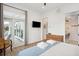 Well-lit bedroom offers a TV, bathroom access, and a sliding door with balcony access at 220 W Arctic Ave, Folly Beach, SC 29439