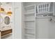 Bright closet with built-in shelving and rack next to bathroom featuring modern lighting and dual sinks at 220 W Arctic Ave, Folly Beach, SC 29439