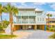 Beautiful, elevated beach house featuring multiple decks, covered parking, and lush landscaping at 220 W Arctic Ave, Folly Beach, SC 29439
