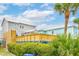 Coastal home featuring a spacious outdoor deck and lush, green landscaping at 220 W Arctic Ave, Folly Beach, SC 29439
