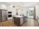 Modern kitchen with stainless steel appliances, white cabinets, and wooden island with barstool seating at 220 W Arctic Ave, Folly Beach, SC 29439