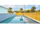 A private swimming pool is surrounded by a wooden fence, palm trees and a light-blue home at 220 W Arctic Ave, Folly Beach, SC 29439