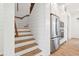 View of the wooden staircase, stainless steel refrigerator, and white cabinets at 220 W Arctic Ave, Folly Beach, SC 29439