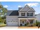 Charming two-story home featuring gray siding, a well-manicured lawn, attached garage, and inviting front porch at 2312 Oakland Rd, Charleston, SC 29414