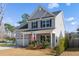 View of two-story home with gray siding, an attached garage, and front porch with an American flag at 2312 Oakland Rd, Charleston, SC 29414