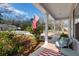 Cozy covered front porch with outdoor seating, landscaping and an American flag at 2312 Oakland Rd, Charleston, SC 29414