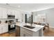 Bright kitchen boasts stainless steel appliances, white cabinetry, and a stylish central island with sink at 2312 Oakland Rd, Charleston, SC 29414