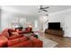 Well-lit living room featuring an orange sectional, hardwood floors, and staircase at 2312 Oakland Rd, Charleston, SC 29414